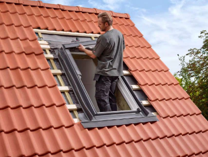 Installateur en train de poser une fenêtre de toit
